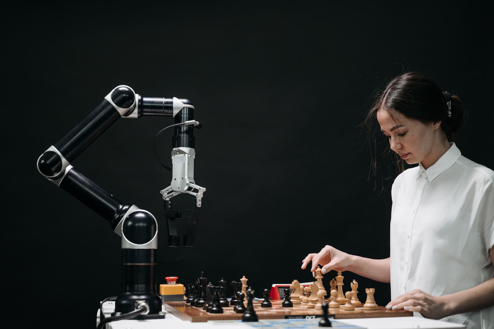 Person playing chess against AI robot