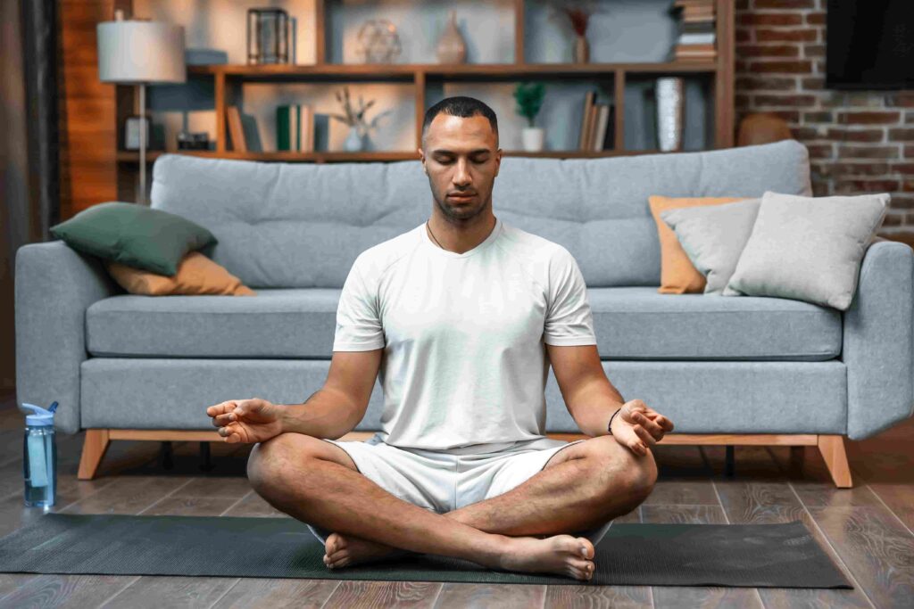 Man sitting in Lotus pose on yoga mat