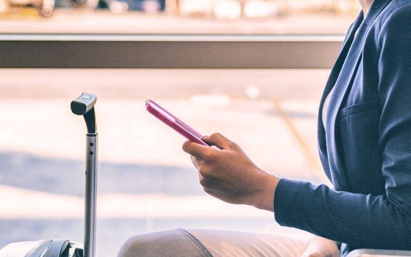 Woman checking phone while waiting for departure flight