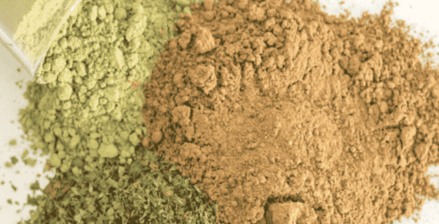 A mixed pile of white, green, and red kratom powders