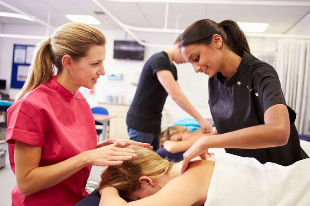 Masseuse training an apprentice during a massage