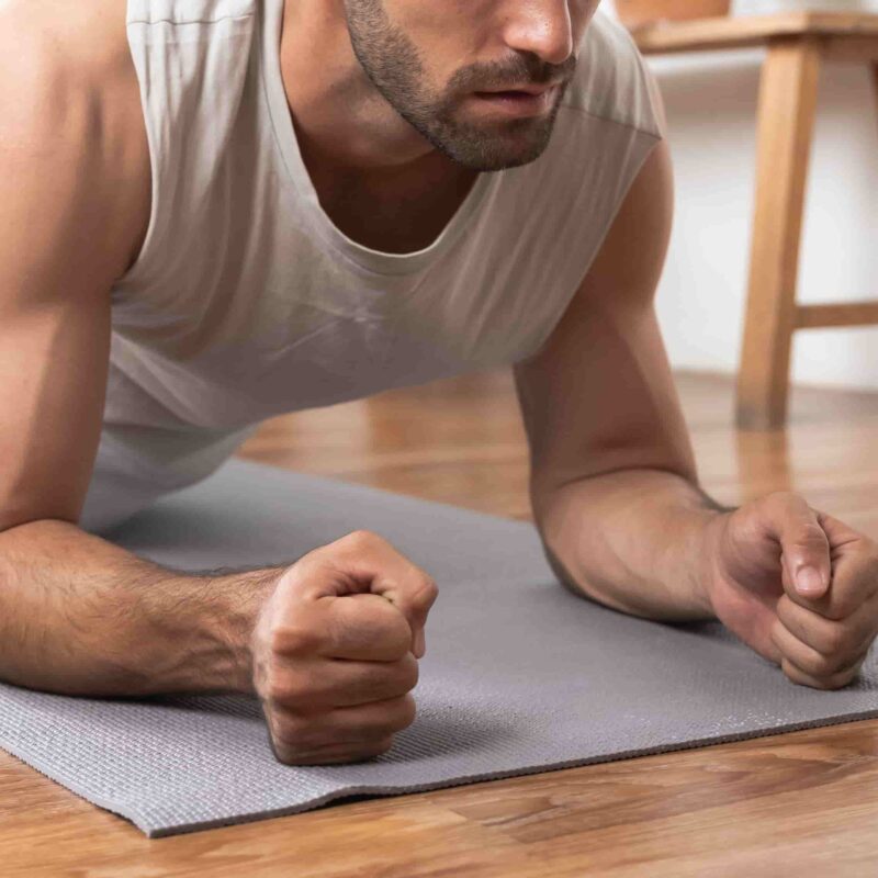 Man doing arm balance on yoga mat