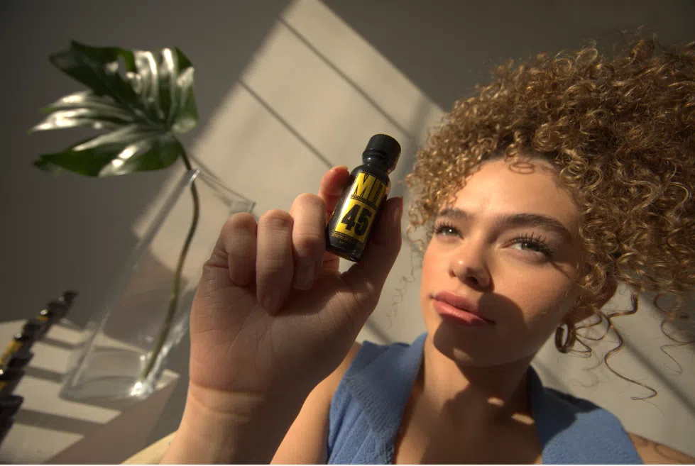 A woman holding a MIT45 Gold Liquid on her hand