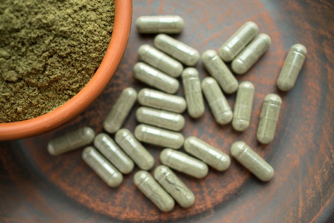 Capsules and powder in a wooden bowl