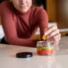 Woman pulling out Boost Bites gummies on kitchen table