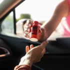 Woman handing Boost bottle through car window