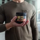 man holding red vein capsules canister
